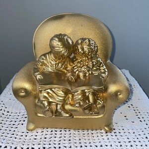 Golden decor of toddlers reading book / bookend